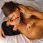 sexy dark haired couple having sex in their bed while kissing