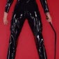 sexy dominatrix dressed in full latex fetish clothing and high heeled boots carrying black whip
