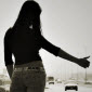 hot hitchhiker in tight jeans and sexy waist thumbing for a ride on the highway under the overpass