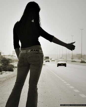 hot hitchhiker in tight jeans and sexy waist thumbing for a ride on the highway under the overpass