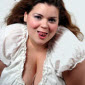 sexy bbw larger curvy woman with large natural breasts in peasant blouse with long brown wavy hair and sticking out her tongue seductively